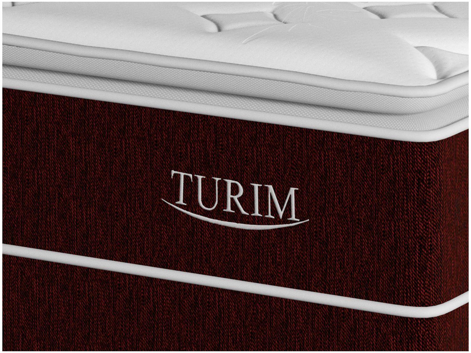 Close-up da lateral da cama box casal vinho com o nome 'TURIM' bordado.