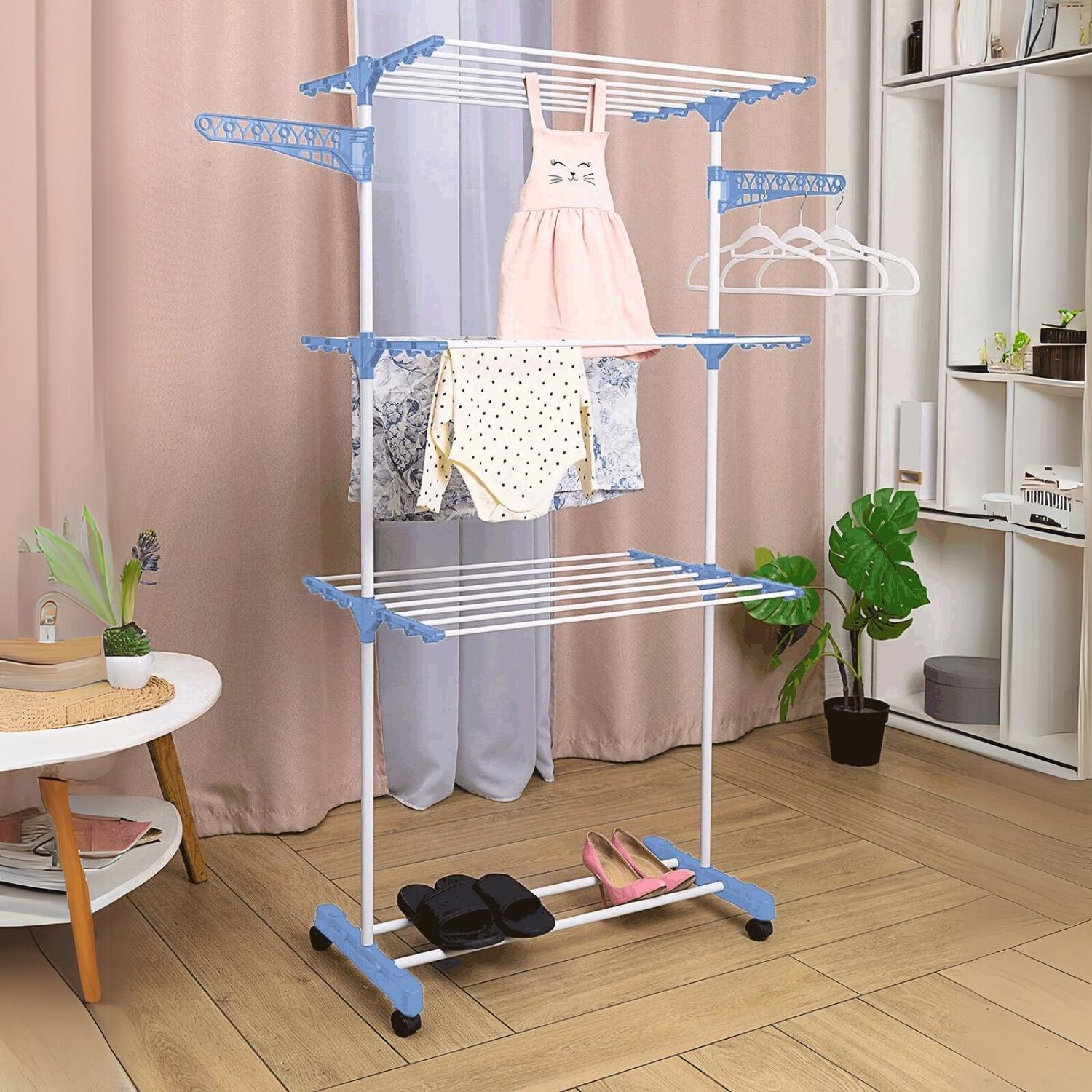 Varal de roupas em ambiente doméstico com itens pendurados e mesa ao lado