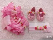 Kit para bebê contendo 1 sandalinha, 1 faixinha e 1 calcinha banda rica na cor rosa .