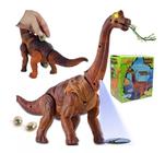 Dinossauro Anda Bota Ovo Som Luz E Movimento Projetor Animal (Marron) - DM TOYS