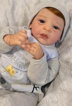Bebê Reborn Menino Corpo de Tecido e Membros Vinil Silicone, Olhos Realistas e Cabelinhos Fio a Fio Enxoval Completo com 18 Itens Pronta Entrega