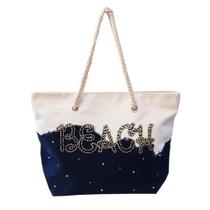 Bolsa Beach com alça estilo corda bordado pérolas e pedrarias. Fechamento com zíper. Forrada.