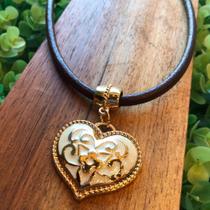 Colar em couro com pingente em formato de coração.