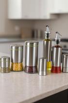 Conjunto De Galheteiro e Porta Condimento 7 Peças em Aço Inox e Vidro Conjunto De Galheteiro e Porta Condimento 7 Peças em Aço Inox e Vidro