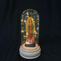 Cúpula de Vidro com LED e Imagem de Nossa Senhora 20cm Ilumine seu ambiente com esta bela cúpula de vidro, que traz a imagem de Nossa Senhora em re