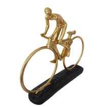 Escultura homem na bike dourada