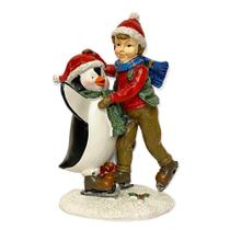 Escultura menino patinando com pinguim