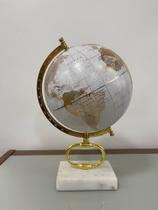 Globo terrestre decorativo com base em pedra e detalhes em dourado.