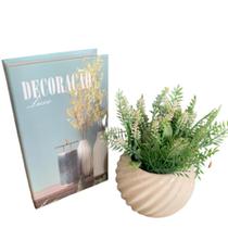 Livro decorativo e vaso branco de cerâmica com trabalhado