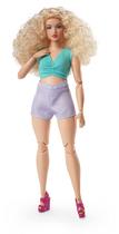 Looks de boneca moderna da Barbie com cabelo loiro encaracolado e shorts lavanda