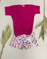Pijama infantil na cor pink com shorts de flores coloridas.