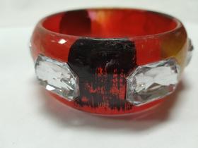pulseira bracelete de acrilico com detalhes preto e dourado com enfeite de pedra vermelho