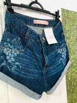 Short jeans, comprimento curto com detalhes estampados de flor.