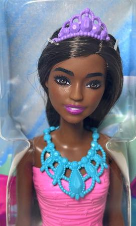 Uma boneca barbie com uma roupa rosa que diz 'menina negra' nela