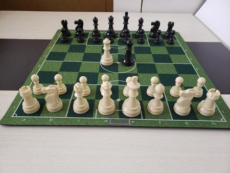 Duas peças, um tabuleiro de xadrez e um relógio em um fundo preto e branco.