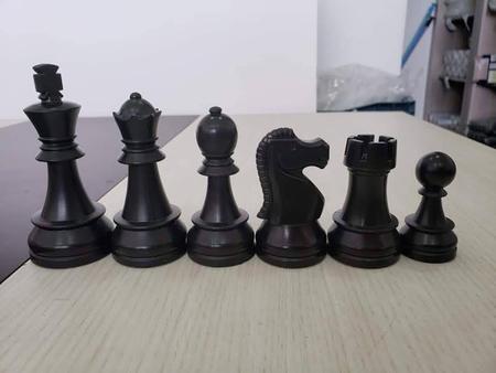 Série de peças de xadrez brancas antes do jogo no tabuleiro preto e branco  sobre fundo preto.