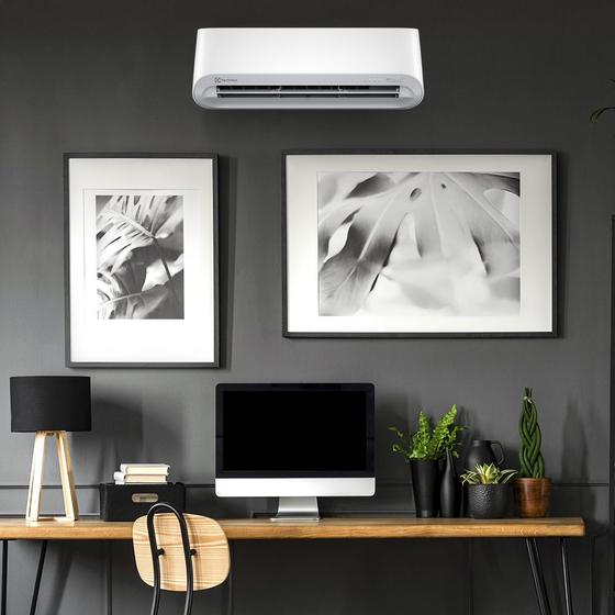 Ar condicionado Electrolux instalado em um escritório moderno acima de uma mesa de trabalho