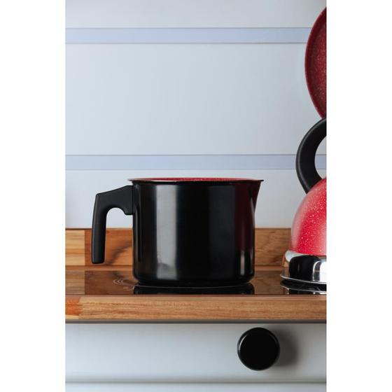 Leiteira Lyor posicionada em um fogão de indução com decoração de cozinha ao fundo