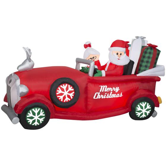 Imagem de Papai Noel e Mamãe Noel infláveis de Natal em carro vermelho