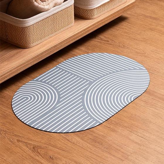 Tapete para banheiro Lyor Contour Three cinza posicionado sobre piso de madeira ao lado de cestos organizadores