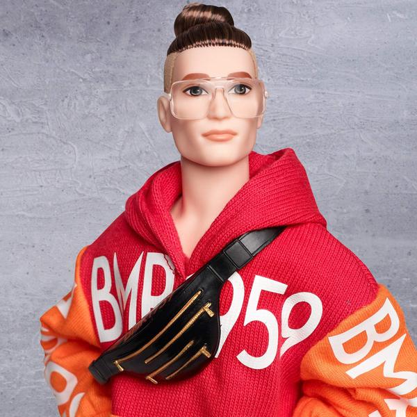 Imagem de Boneco Ken, Barbie, camiseta com logotipo BMR1959, bermudas listradas e bolsa em forma de cintura.