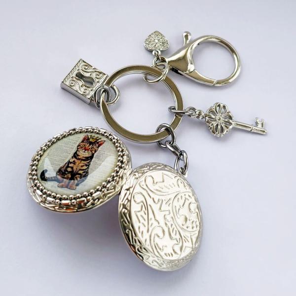 Chaveiro Pingente Relicário Fotos Resina Gato Rei Prateado - Regina Bijoux Imagem de Chaveiro Pingente Relicário Fotos Resina Gato Rei Prateado