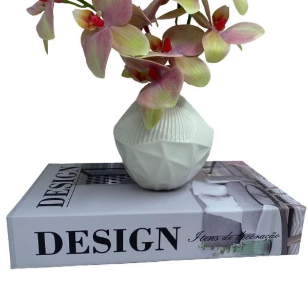 Imagem de Livro decorativo e vaso branco de cerâmica com orquídea