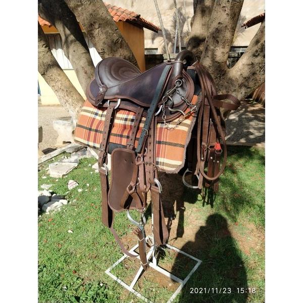 Imagem de Sela Australiana Marrom Arreada para cavalo com manta quarto de milha xadrez, cabresto e freio para lida fazenda sítio